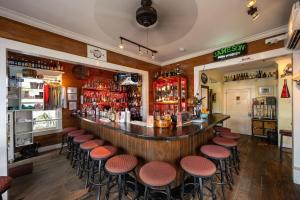 a bar with a bunch of stools in a room at NIGHTCAP @ Speakeasy Inn Key West! in Key West