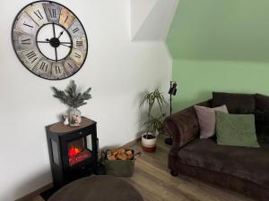 a living room with a couch and a clock on the wall at Harz Flair Schierke in Schierke