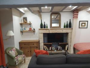 a living room with a couch and a fireplace at Maisonette, Gîte de la Mère Nini in Saint-Laon