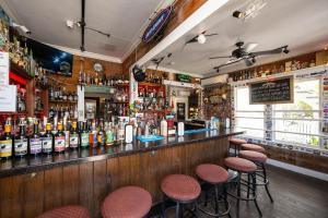 a bar with stools and bottles of alcohol at AFTER HOURS @ Speakeasy Inn Key West! in Key West