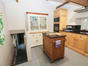 a kitchen with white cabinets and a black refrigerator at The Tithe Barn in Barnard Castle