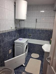 a bathroom with a washing machine and a sink at Stan na dan Mara in Bijeljina