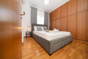 a bedroom with a large bed with wooden cabinets at 2 bedroom flat in Strovolos