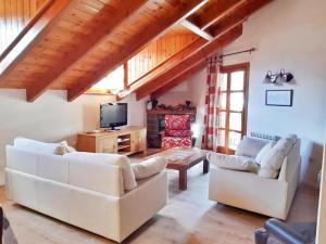 a living room with two white couches and a tv at San Marsial Benasque Apart Hotel in Benasque
