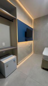 a room with a bed and a tv on the wall at Pousada Meireles in Fortaleza