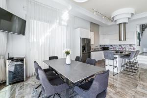a kitchen and dining room with a table and chairs at Olymp Luxury Villa А - Beachfront Luxury Living in Kissonerga +53 photos