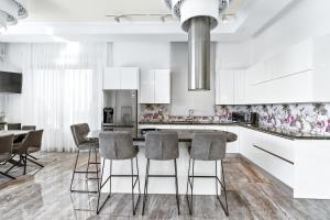 a kitchen with white cabinets and a table and chairs at Olymp Luxury Villa А - Beachfront Luxury Living in Kissonerga