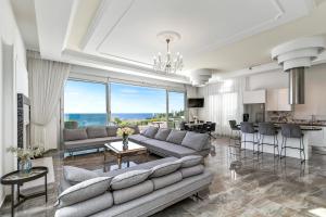 a living room with a couch and a table at Olymp Luxury Villa А - Beachfront Luxury Living in Kissonerga