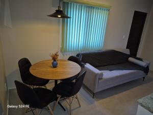 a living room with a table and a couch at Apartamento de curta temporada - ótimo padrão - próximo Lagoa de Iriry in Rio das Ostras