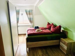 a bedroom with a bed with red sheets and a mirror at Harz Flair Schierke in Schierke +23 photos