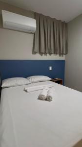a white bed with a fan and two shoes on it at Pousada Meireles in Fortaleza