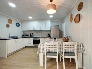 a kitchen with a table and chairs and a refrigerator at Casa do Portinho - Sea View House - in São Roque