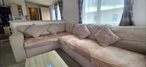 a brown couch in a living room with a window at Joy & Mick's Happy Place in Morecambe