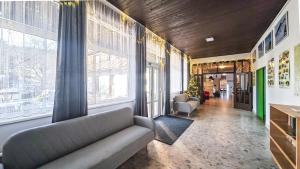 a living room with a couch and large windows at Penzion Vápenka in Horní Maršov