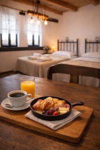 a table with a plate of food and a cup of orange juice at Bujtina Maria in Gjirokastër