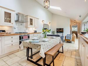 a kitchen with white cabinets and a table with flowers on it at 2 Bed in Ventnor oc-88857 in Niton +12 photos
