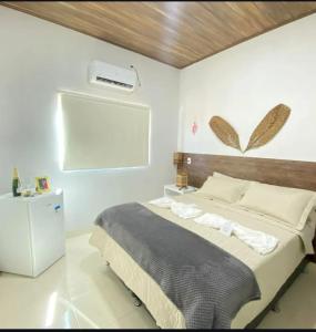 a bedroom with a bed and a air conditioner on the wall at Pousada Vereda Encantada in São Félix do Tocantins