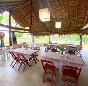 a group of tables and chairs in a pavilion at Pousada Vereda Encantada in São Félix do Tocantins