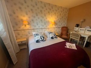a hotel room with a bed with two pillows at Les 3 rois by YY in Villers-Bocage +101 photos