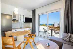 een woonkamer met een tafel en een keuken met uitzicht bij Punta Mare Hotel in Karpathos