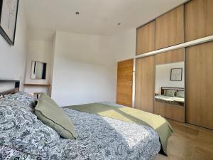a bedroom with a large bed and a mirror at Gîte du Colombier in Crestet