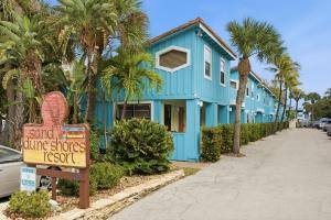 a blue house with a sign in front of it at Sand Dune Shores in Palm Beach Shores