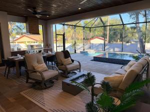 a living room with a couch and chairs and a pool at New Upscale & Modern Heated Pool Home in Walkable Downtown! in Sarasota