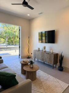 a living room with a couch and a tv at New Upscale & Modern Heated Pool Home in Walkable Downtown! in Sarasota