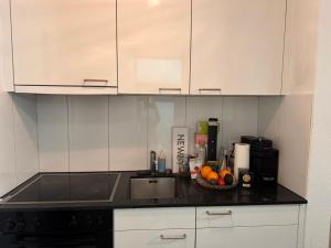 a kitchen with white cabinets and a bowl of fruit at Zürich 8008 Appartement in Zurich