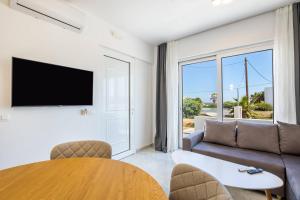 een woonkamer met een bank en een tafel bij Punta Mare Hotel in Karpathos
