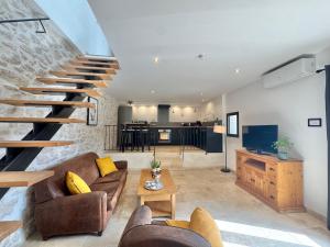 a living room with a couch and a staircase at Gîte du Colombier in Crestet