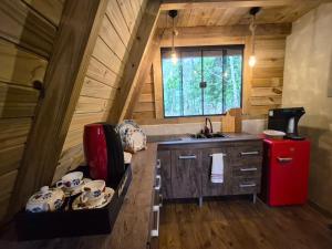 a small kitchen with a red refrigerator in a cabin at Chales Holanda in Pirenópolis