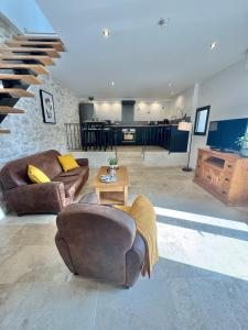 a living room with two couches and a staircase at Gîte du Colombier in Crestet