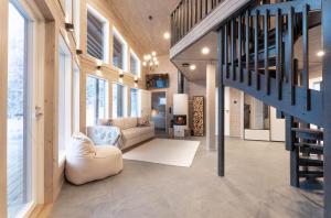 a living room with a staircase in a house at Villa Vaellus in Ruka