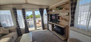 a living room with a couch and a tv and a tv at Joy & Mick's Happy Place in Morecambe