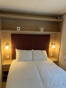 a bedroom with a large bed with a wooden headboard at Joy & Mick's Happy Place in Morecambe