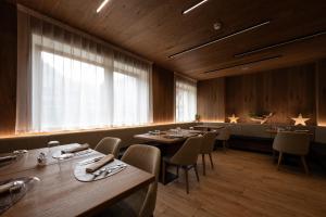 a dining room with tables and chairs and a window at Hotel Cristina Wellness Relax in Pinzolo +71 photos