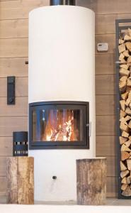 a fireplace with a fire in the wall at Villa Vaellus in Ruka