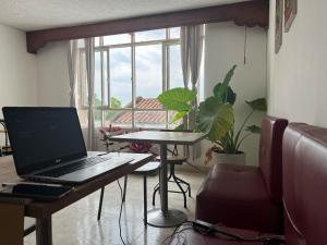 a laptop computer on a table in a room with a window at Casa Epifania Miraflores hostel in Cali