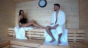 a man and a woman sitting in a sauna at Nomad by Hora cu Brazi in Zărneşti