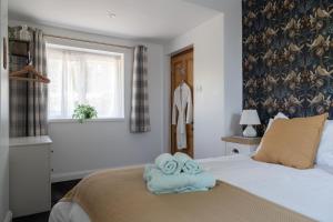 a bedroom with a bed with towels on it at Stanton Lodge Cottage - 2 bedrooms - sleeps 5 in Curbar