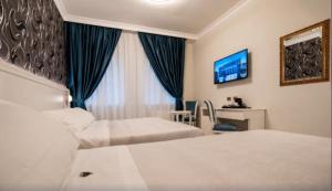 a hotel room with two beds and a tv at Hotel Sicilia in Enna +39 photos