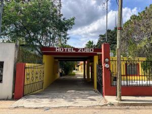 Ein Hoteleingang zu einem Gebäude mit Zaun in der Unterkunft Hotel Casa Zued chichen itza in Pisté