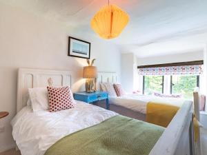a bedroom with two beds and a blue table at 4 Bed in Buxton oc-57687 in Millers Dale