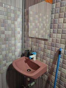 a pink sink in a bathroom with a mirror at Unpack Hostel in Pondicherry +70 photos