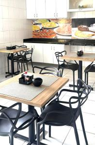 a table and chairs in a kitchen with plates of food at Hotel Sambaquis in São Luís