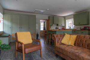 a living room with a couch and a kitchen at Stanton Lodge Cottage - 2 bedrooms - sleeps 5 in Curbar