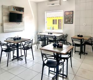 a restaurant with tables and chairs and a tv at Hotel Sambaquis in São Luís