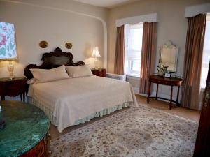 a bedroom with a bed and two tables and a mirror at Turkey Hill Inn in Summit
