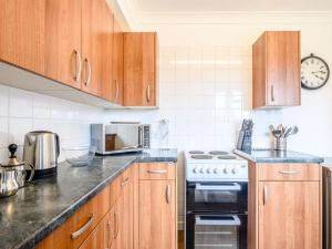 a kitchen with wooden cabinets and a stove top oven at 2 Bed in Holt oc-73518 in Holt